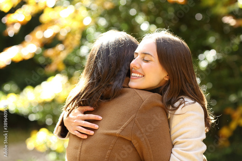 Billede på lærred Happy friends meeting and hugging in a park in autumn