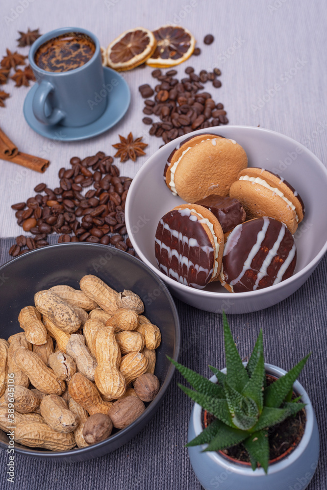 A cup of espresso is decorated with anise stars, cinnamon, sweets, dried lemons, acorns, peanuts in a beautiful dish. A cup of espresso is decorated with anise stars, cinnamon, sweets, dried lemons, acorns, peanuts in a beautiful dish.