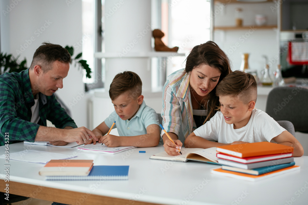 Parents helping the kids with their homework. Litlle boys learning at home.. Parents helping the kids with their homework. Litlle boys learning at home..