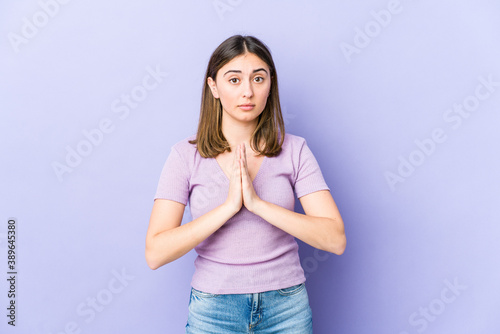 Young caucasian woman praying, showing devotion, religious person looking for divine inspiration.