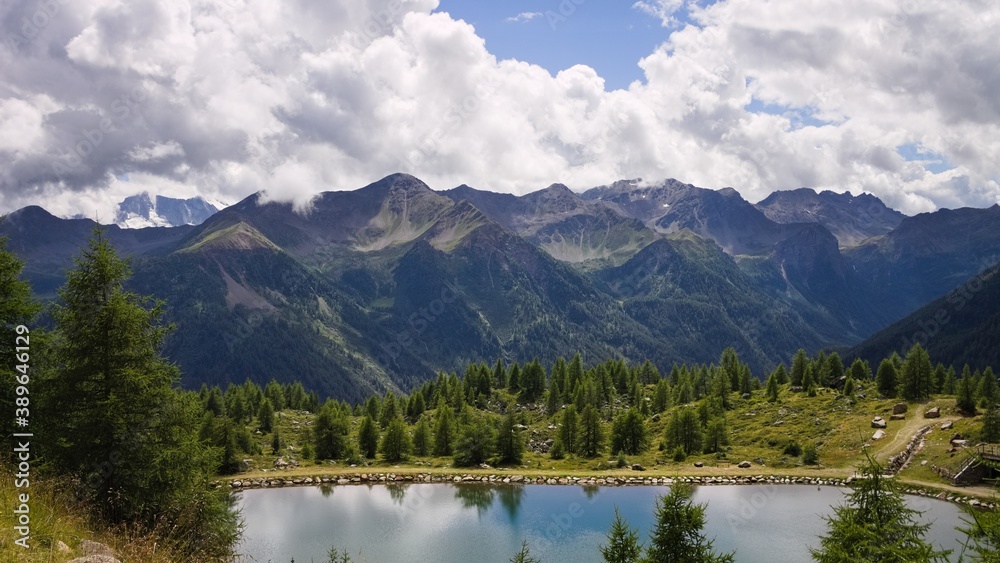 A lake in the Italian Alps with a forest and mountains in background (Trentino, Italy, Europe)