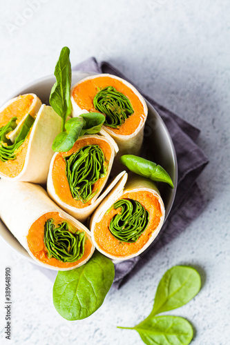 Vegan tortilla wraps with sweet potato and spinach, gray background, top view. Healthy vegetarian food concept.