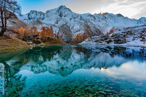 Reflections of snow capped mountains in a blue icy lake in the mountains © Graham