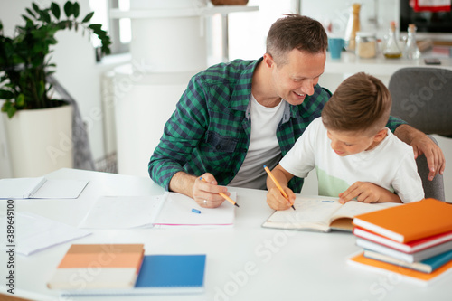 Father helping his son with homework at home. Little boy learning at home..