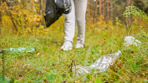 Young woman collecting trash in the forest.