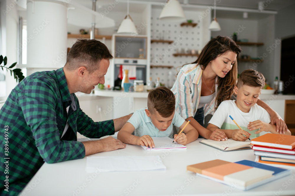 Parents helping the kids with their homework. Litlle boys learning at home.. Parents helping the kids with their homework. Litlle boys learning at home..
