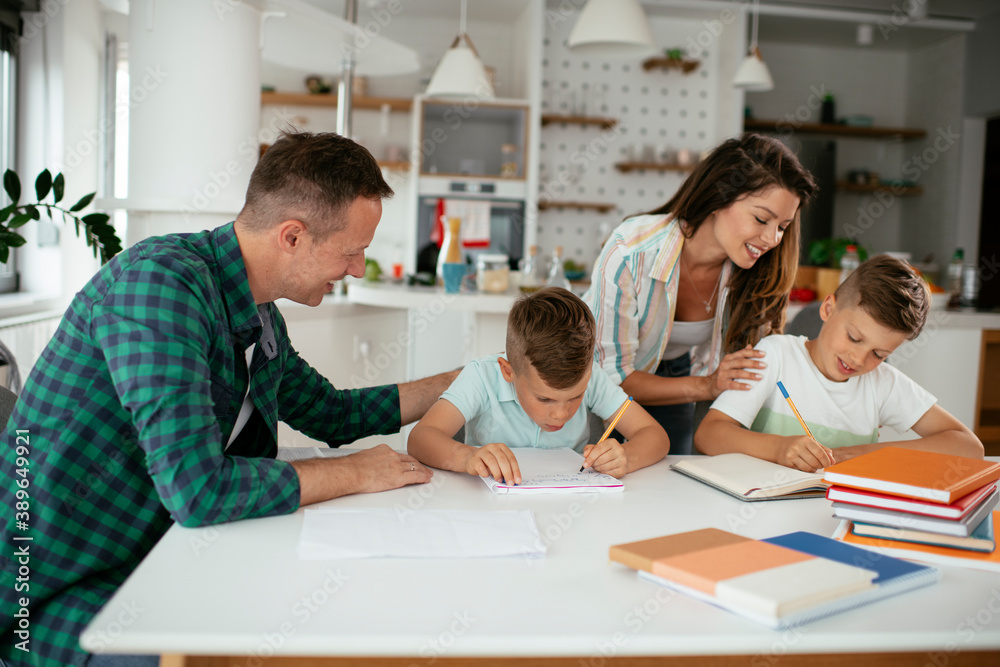 Parents helping the kids with their homework. Litlle boys learning at home.. Parents helping the kids with their homework. Litlle boys learning at home..
