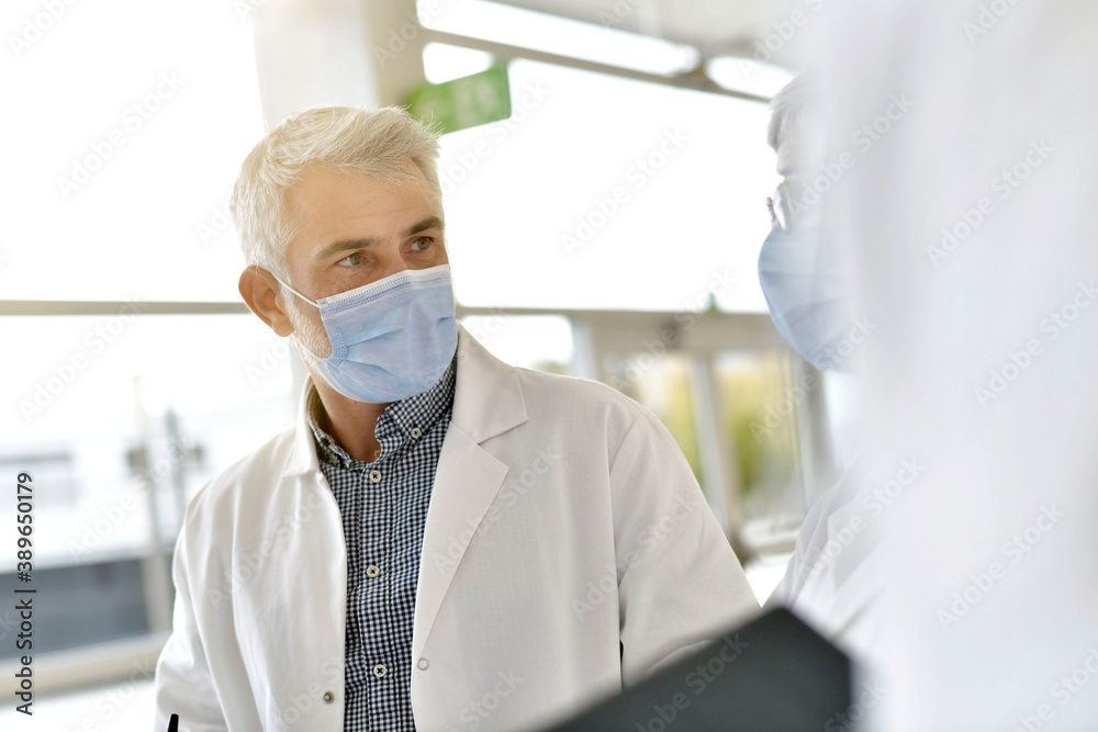 Doctor in hospital giving 19-ncov instructions to colleague Doctor in hospital giving 19-ncov instructions to colleague