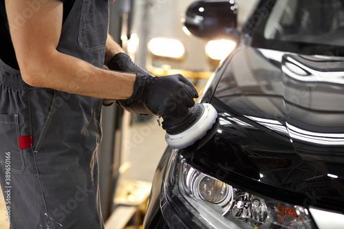 Fotografie hard-working auto mechanic worker polishing car at automobile repair service, re