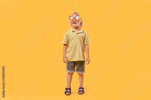 Horizontal image of a school-age boy wearing a mask and snorkel during the summer holidays. A beautiful boy with blond hair and curly hair.