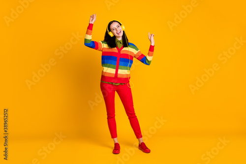 Full body photo of young attractive girl listen music radio headphones enjoy dance isolated over yellow color background