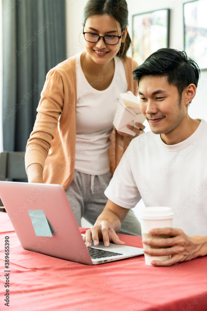 Asian couple working from home with take out food. Asian couple working from home with take out food.