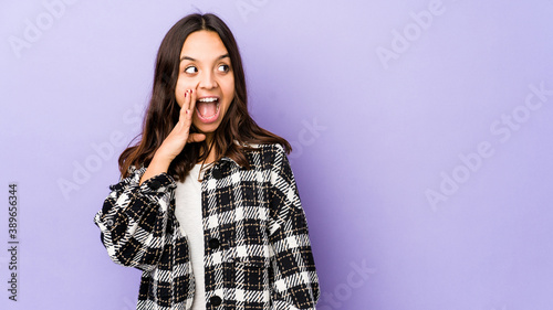 Young mixed race hispanic woman isolated shouting excited to front. © Asier