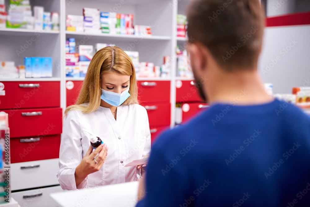 young caucasian helpful female druggist dealing with a male customer, explaining a prescription to ill patient, client