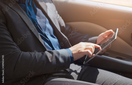 Young businessman using tablet inside the car