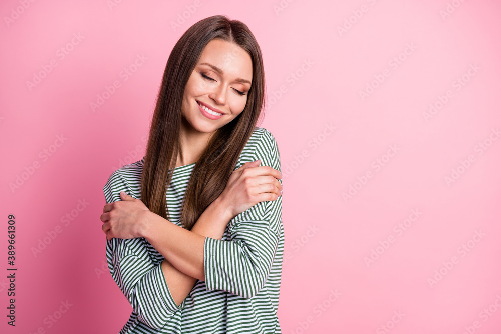 Photo of lovely girl closed eyes cuddle herself toothy smile wear striped shirt isolated pastel pink color background Photo of lovely girl closed eyes cuddle herself toothy smile wear striped shirt isolated pastel pink color background