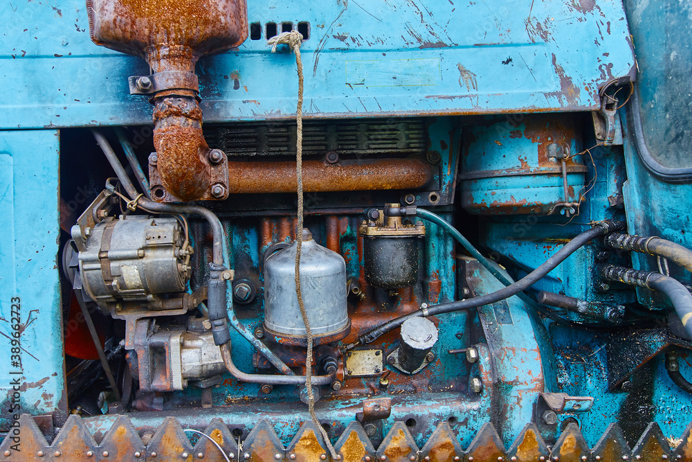 View of an old oiled and rusted tractor engine, background