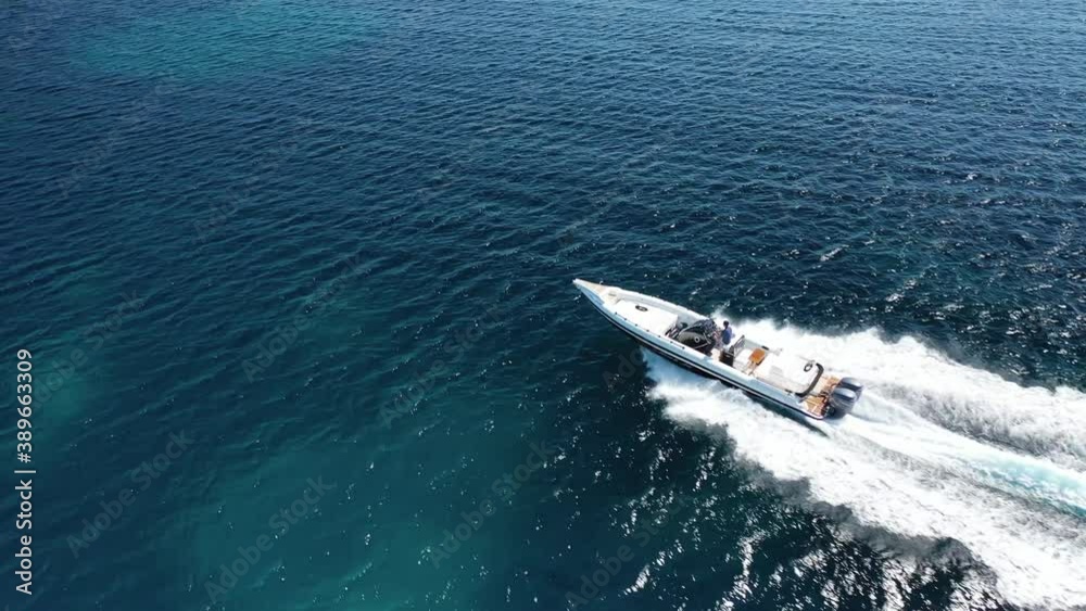 Aerial drone video of inflatable rib speed boat cruising open ocean deep blue sea