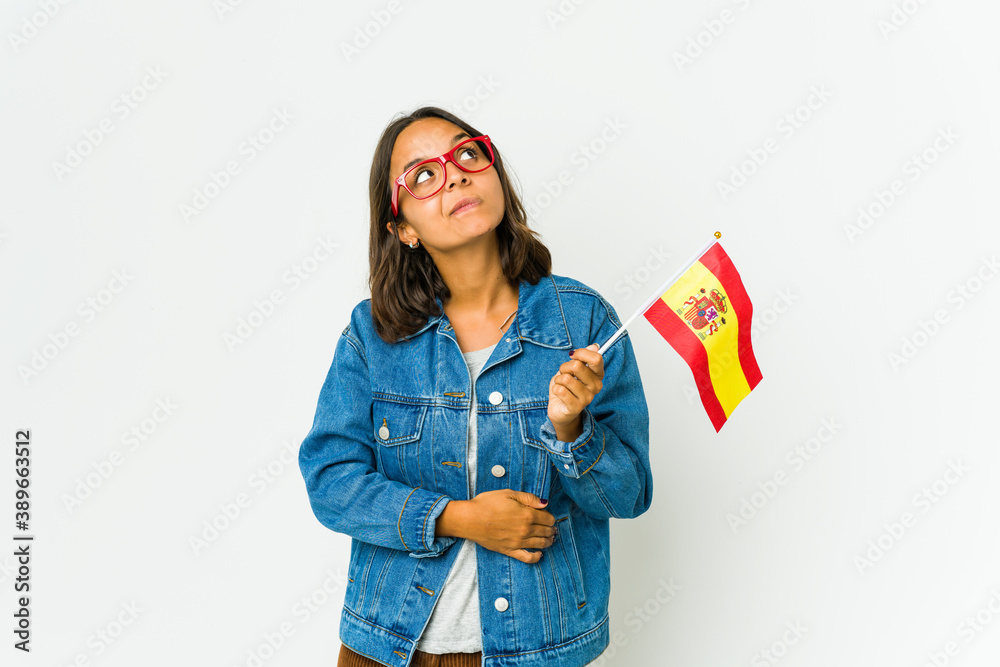 Young spanish woman holding a flag isolated on white background