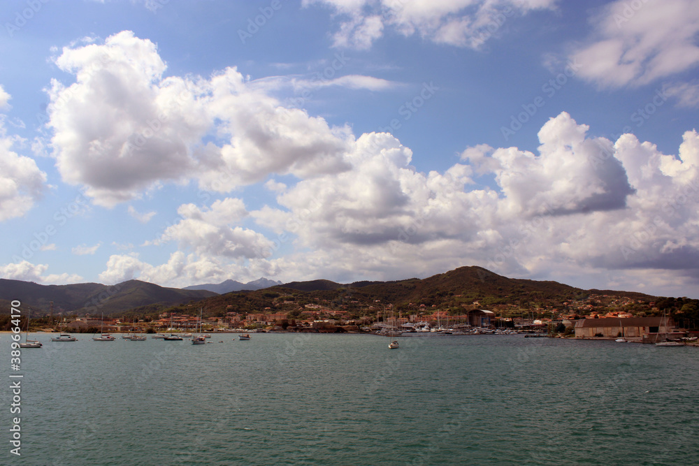 La costa di Portoferraio vista dal mare con cielo e nuvole