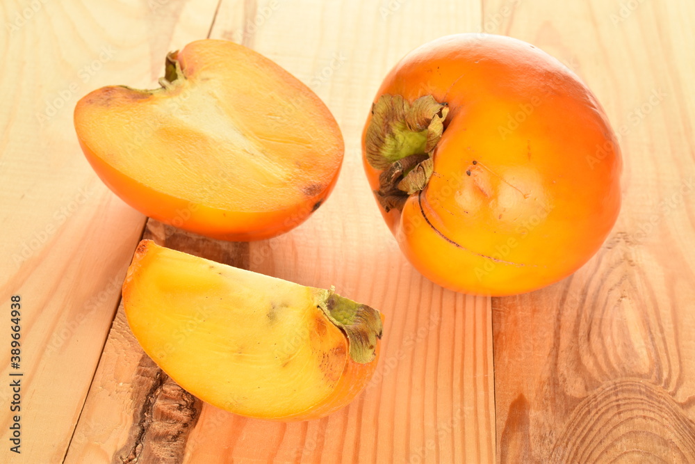 Ripe juicy organic persimmon, close-up, on a wooden table.
