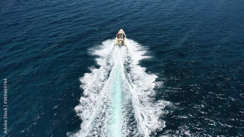 Aerial drone video of inflatable rib speed boat cruising open ocean deep blue sea