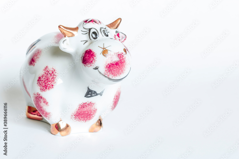 Porcelain figurine of a bull white and purple on a white background. New year of the bull Porcelain figurine of a bull white and purple on a white background. New year of the bull