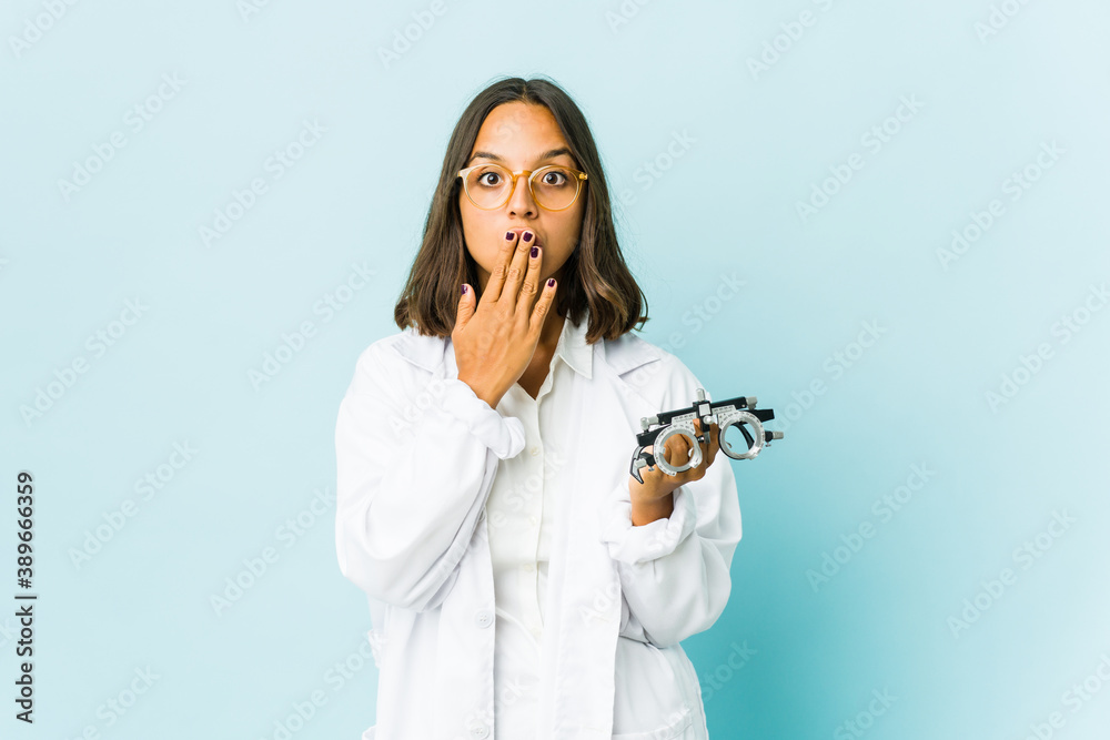 Young oculist latin woman over isolated background