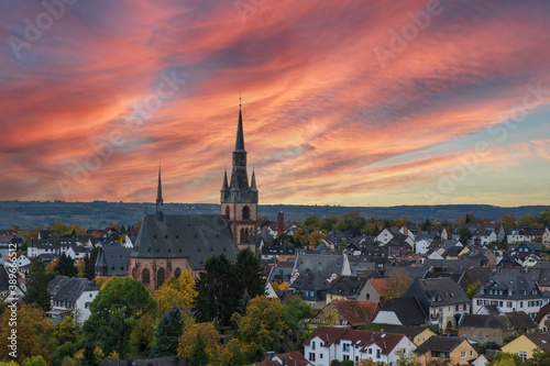  View of the cathedral of Kiedrich / Germany in the Rheingau with a dramatic red discolored evening sky © fotografci