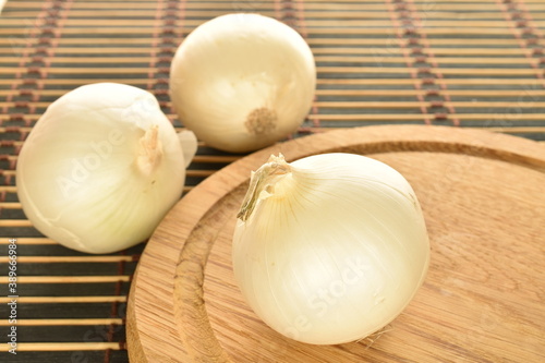 Ripe white organic onions  close-up  on a bamboo mat.