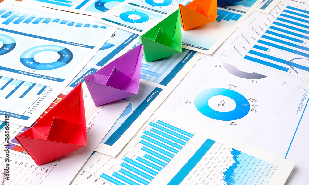 Ships made of colored paper on business charts. Teamwork concept. Ships made of colored paper on business charts. Teamwork concept.