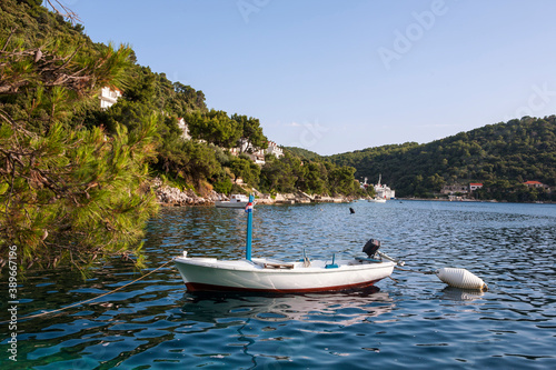 The pretty ferry port of Ubli in the bay of Velji Lago on Lastovo, Dubrovnik-Neretva, Croatia, with a little fishing boat at anchor in the foreground