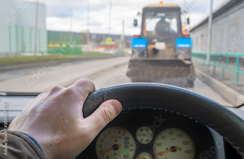 Картината върху платно driver hand on the steering wheel of a car that is traveling on the roadway in a