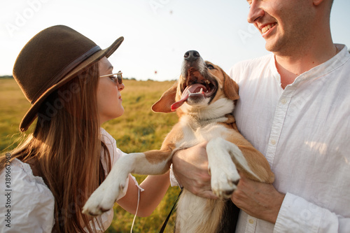 happy couple in love with a dog in a field in nature