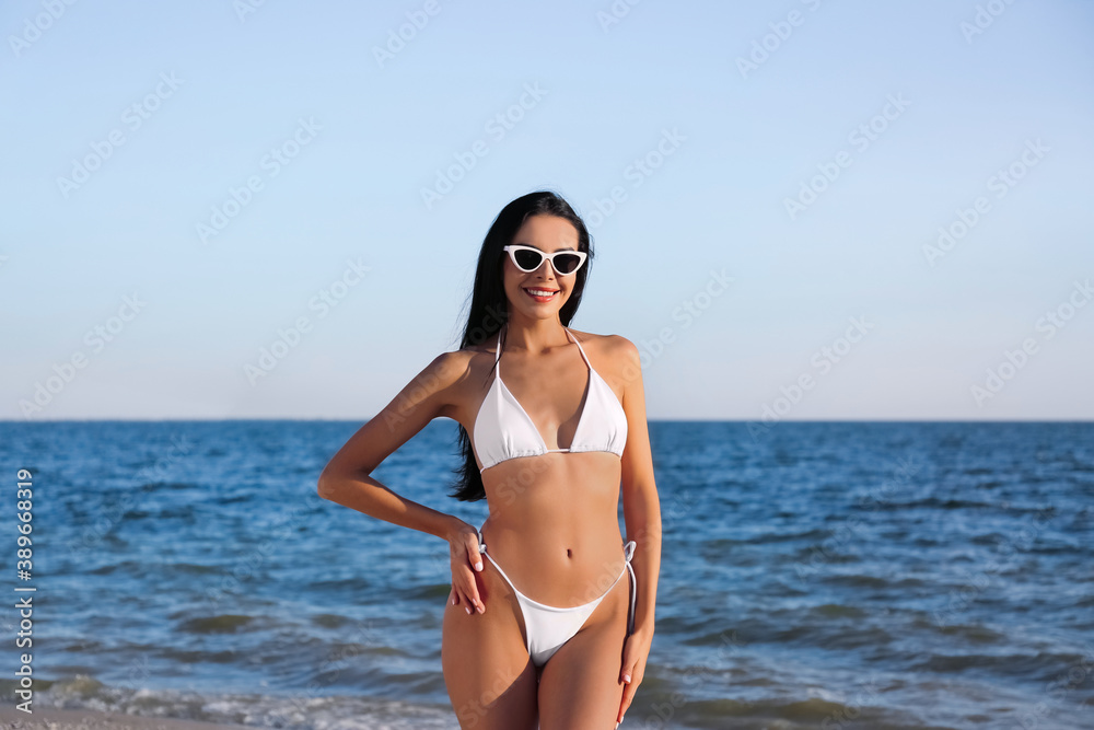 Beautiful young woman in white stylish bikini on beach Beautiful young woman in white stylish bikini on beach