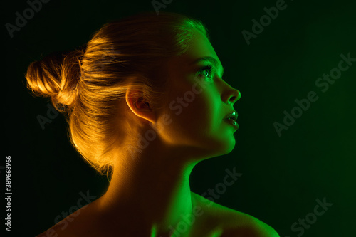 Passioned. Portrait of female fashion model in neon light on dark studio background. Beautiful caucasian woman with trendy make-up and well-kept skin. Vivid style, beauty concept. Close up. Copyspace