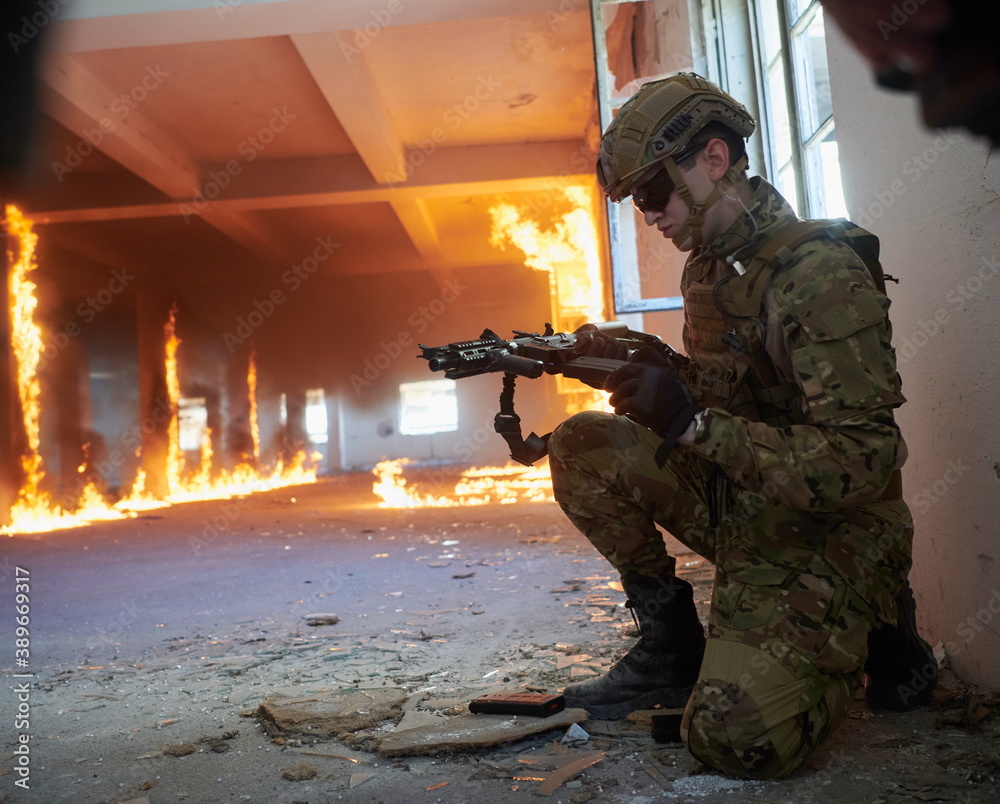 Fototapeta premium soldier in action near window changing magazine and take cover