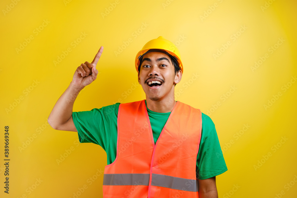 Asian construction worker wearing orange vest and har hat is seen looking for ideas