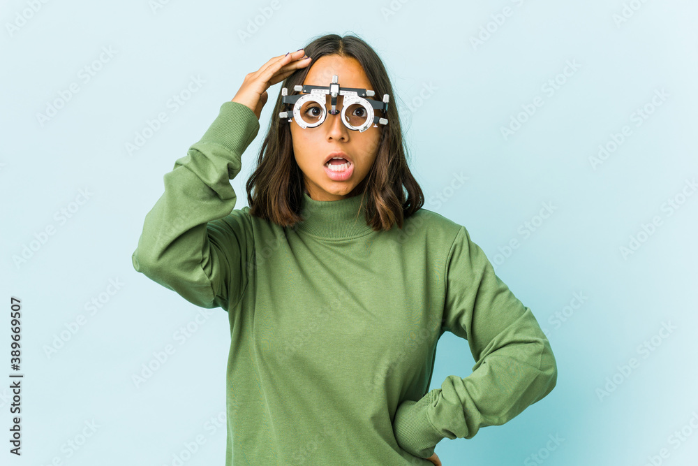 Young oculist latin woman over isolated background Young oculist latin woman over isolated background