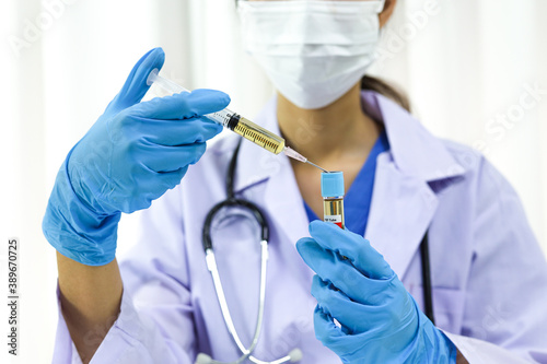 Hand holding syringe and vaccine treatment from Coronavirus covid-19 infection.