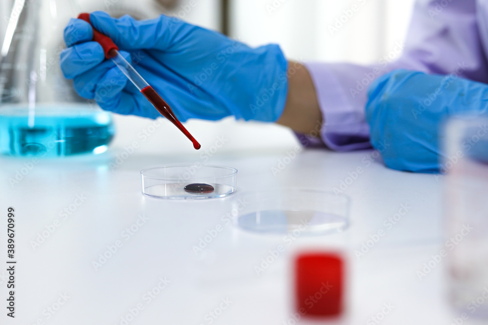 Scientist holding Coronavirus covid-19 infected blood sample tube DNA testing of the blood in the laboratory with blood sample collection tubes and syringe Coronavirus Covid-19 vaccine research. Scientist holding Coronavirus covid-19 infected blood sample tube DNA testing of the blood in the laboratory with blood sample collection tubes and syringe Coronavirus Covid-19 vaccine research.