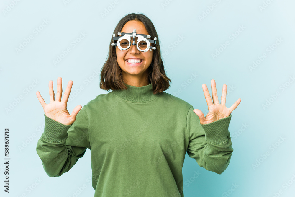Young oculist latin woman over isolated background