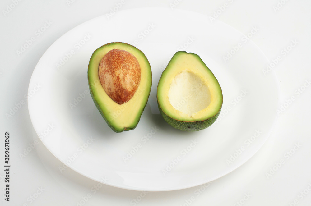 Two slices of avocado on a plate isolated on a white background. Top view