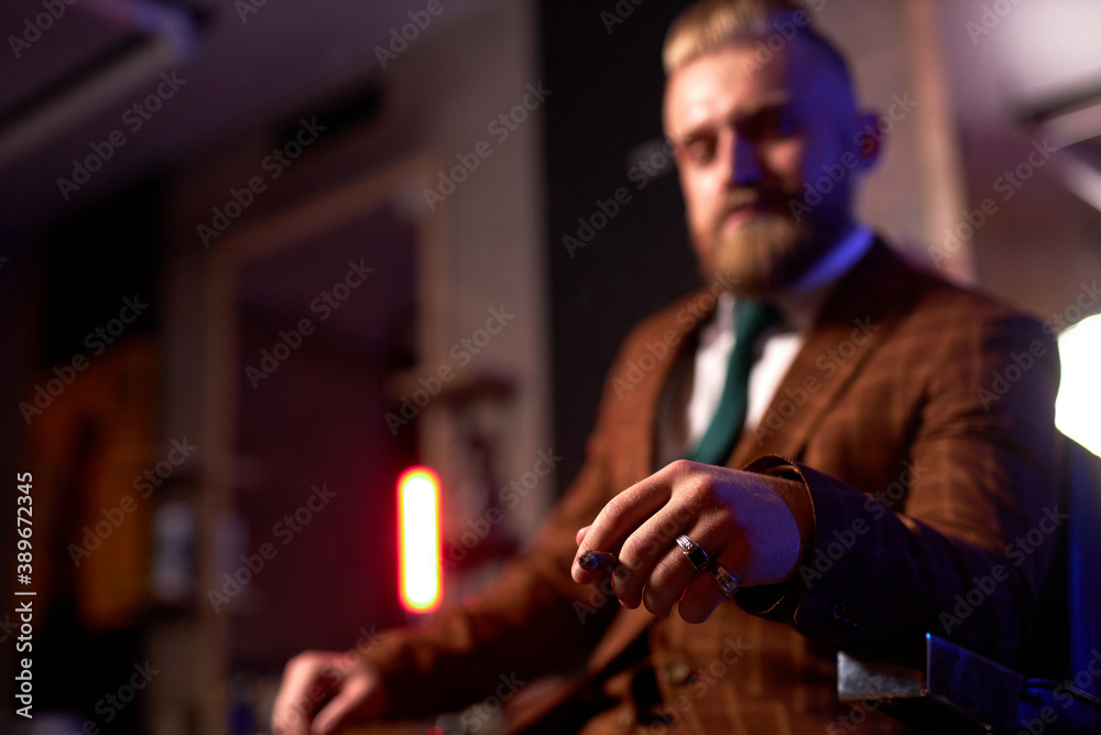 close-up photo of cigar in hand on confident rich guy sitting in dark room smoking alone close-up photo of cigar in hand on confident rich guy sitting in dark room smoking alone