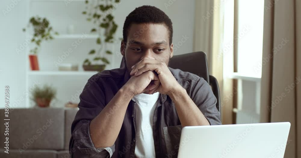Portrait of pensive man business analyst freelancer author writer student sitting at table at home in front of computer with folded hands near chin thinking about project of creative idea dreaming Portrait of pensive man business analyst freelancer author writer student sitting at table at home in front of computer with folded hands near chin thinking about project of creative idea dreaming