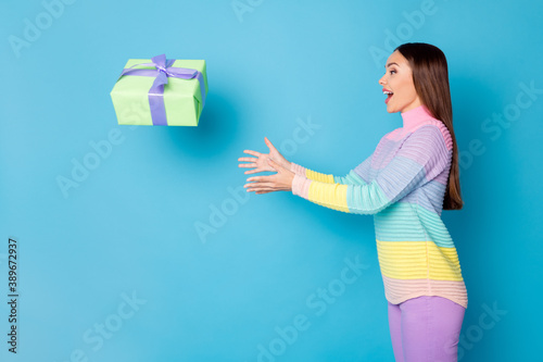 Profile side photo of astonished girl get gift box air fly catch wear trousers sweater isolated blue color background