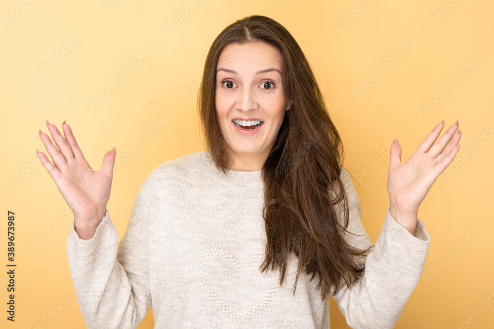 Joyfully shocked Tatar brunette girl splashes her hands with open mouth and surprised face isolated in yellow studio. Good news, sale concept Joyfully shocked Tatar brunette girl splashes her hands with open mouth and surprised face isolated in yellow studio. Good news, sale concept