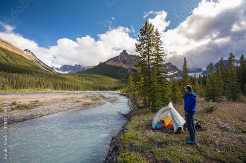 Man standing next to tent near Castleguard Meadows, Banff Park. photo