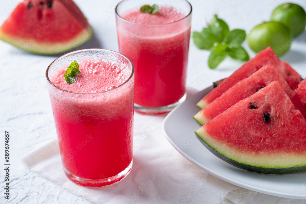 Watermelon smoothie topping with fresh mint leaves on wood background Watermelon smoothie topping with fresh mint leaves on wood background