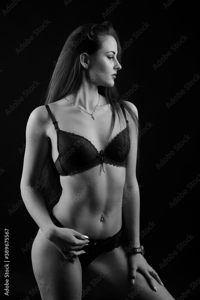 Sexy fashion brunette woman with long dark hair in blue lingerie, isolated on dark gray background